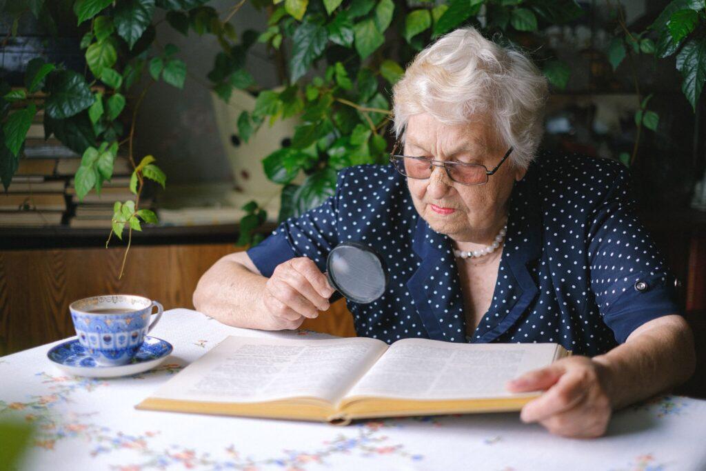 Claus Sølvsteen Nærbillede af ældre dame som læser med lup